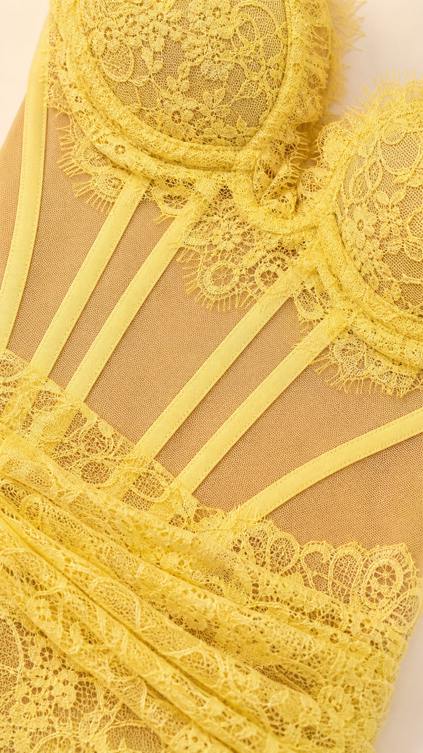 Close-up detail of yellow floral lace and boned corset bodice