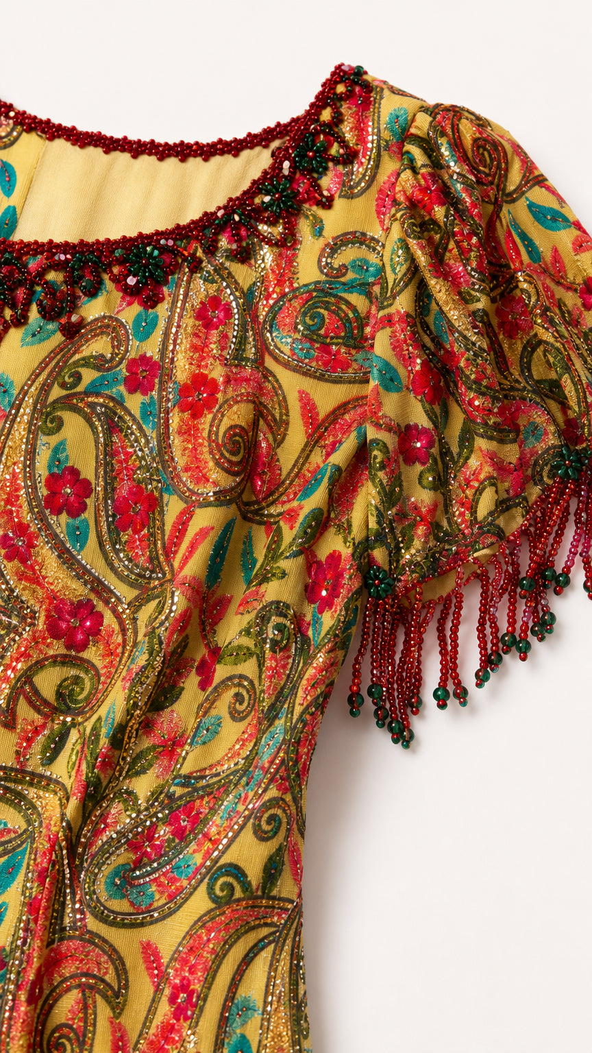 Close-up of scoop neckline and sleeve hem with intricate multicolor beadwork and fringe