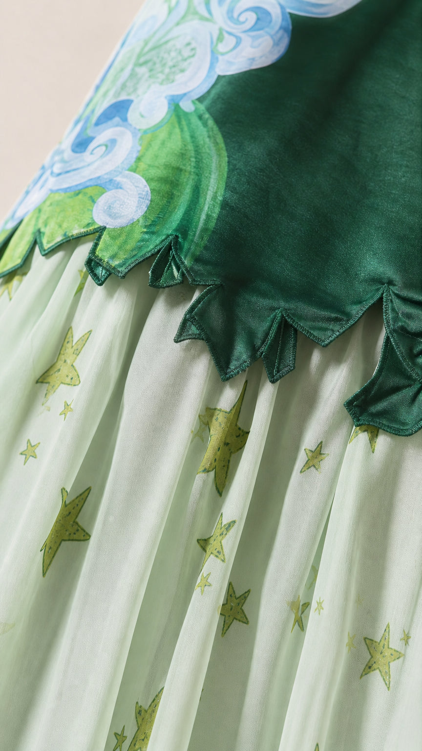 Close-up detail of scalloped hem and star-printed pleated chiffon