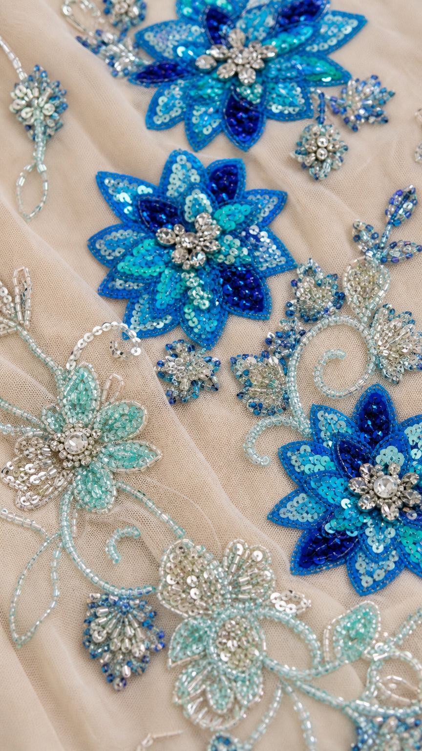 Close-up detail of blue and silver sequin and beaded floral embroidery on mesh