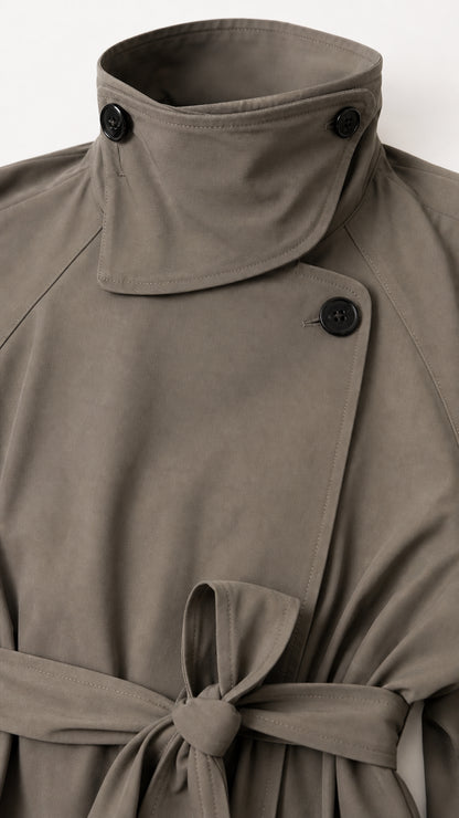 Close-up detail of high stand buttoned collar and waist belt knot on trench coat