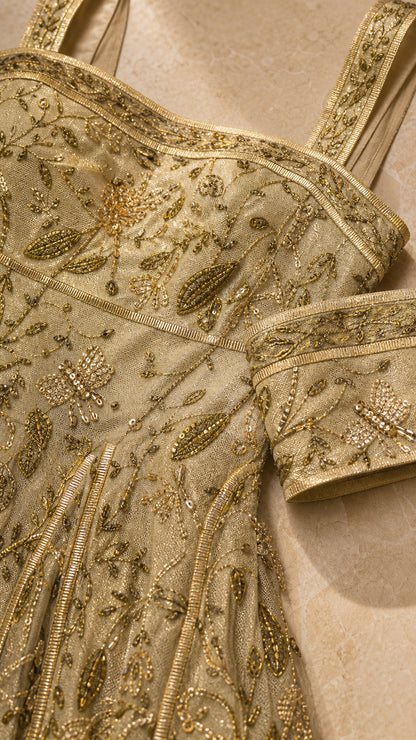 Close-up detail of metallic floral embroidery and beading on square neckline and bodice