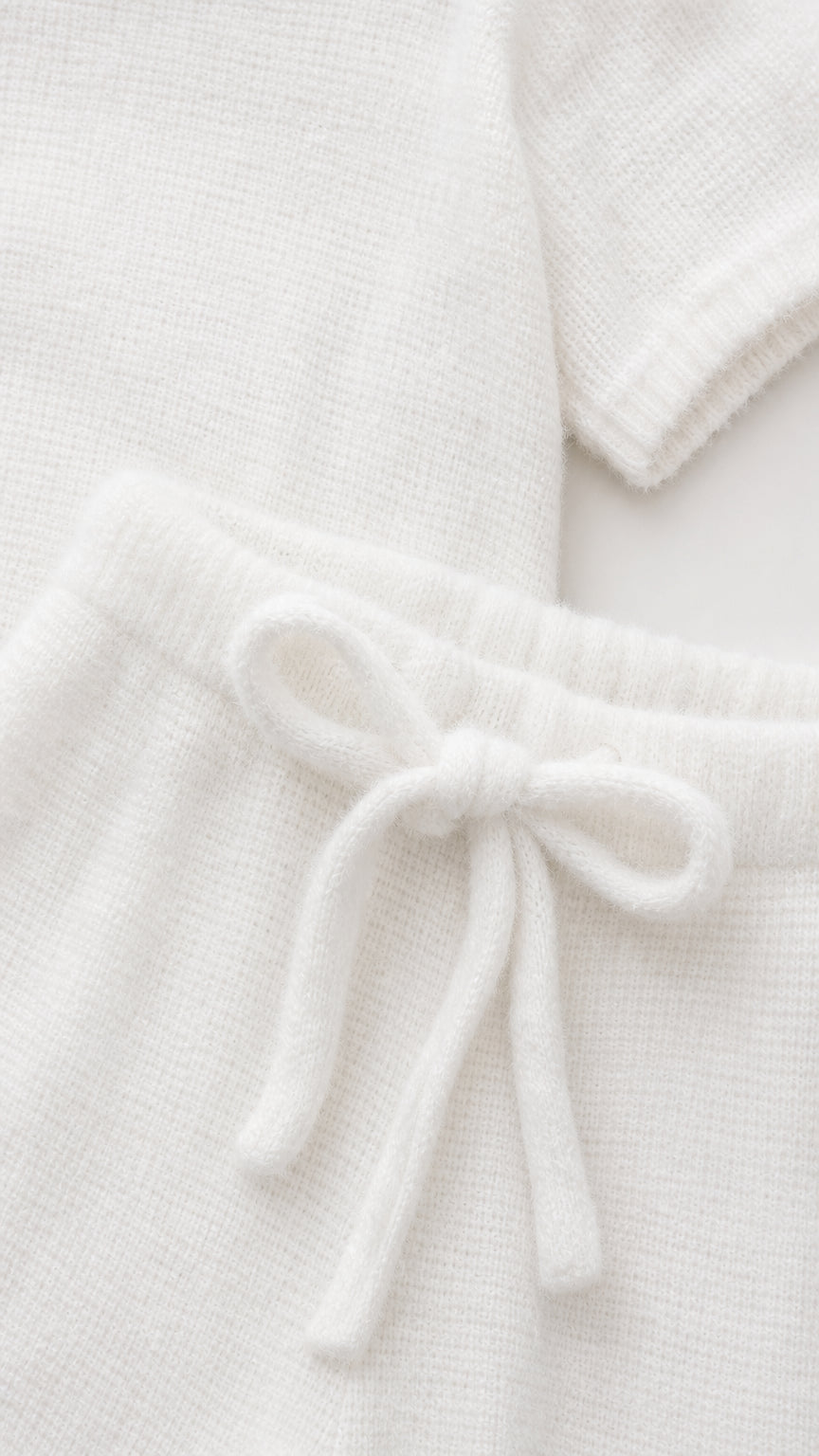 Close up detail of soft white knit texture and drawstring waistband