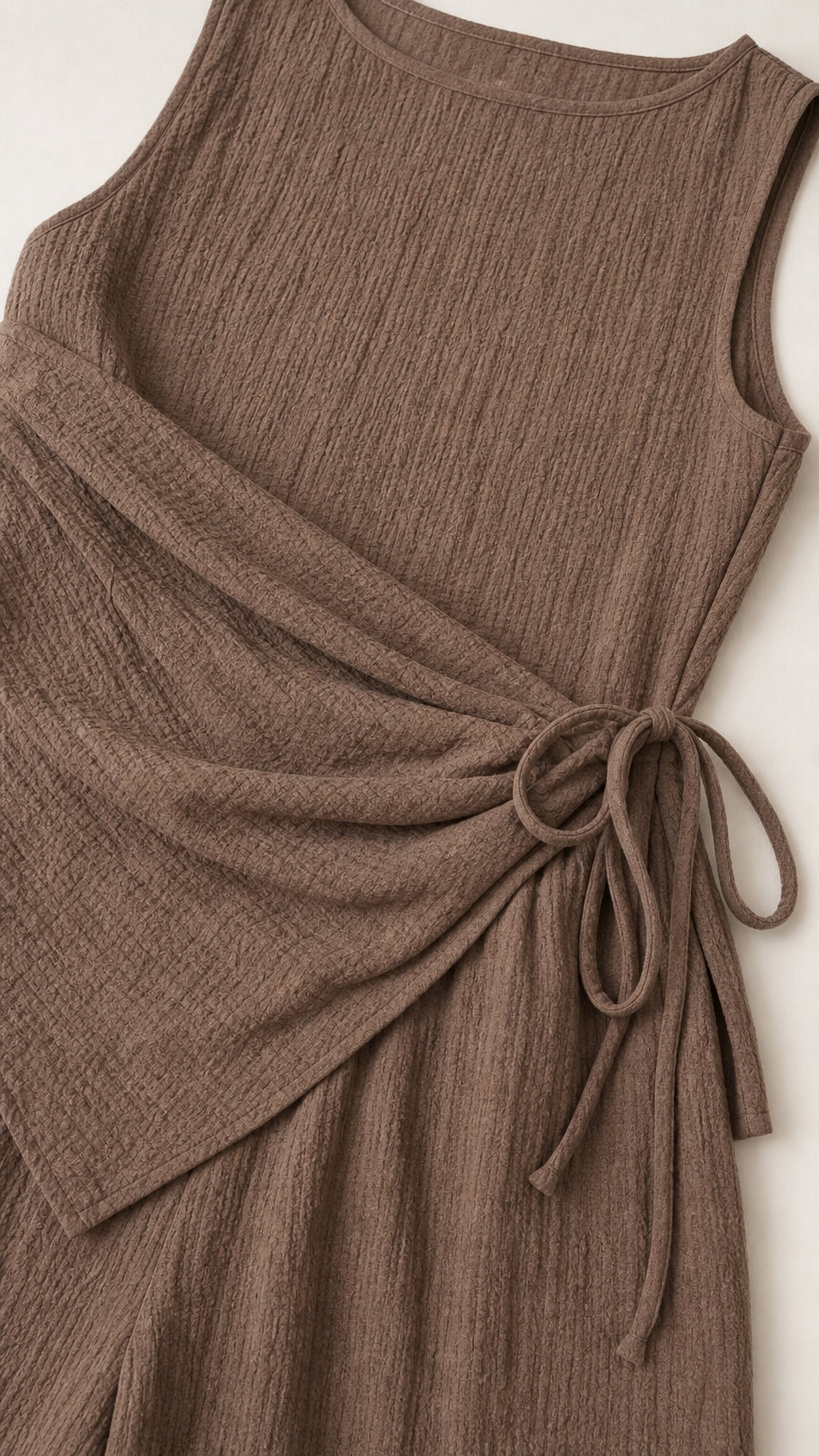Close up of textured fabric and side tie detail on brown top