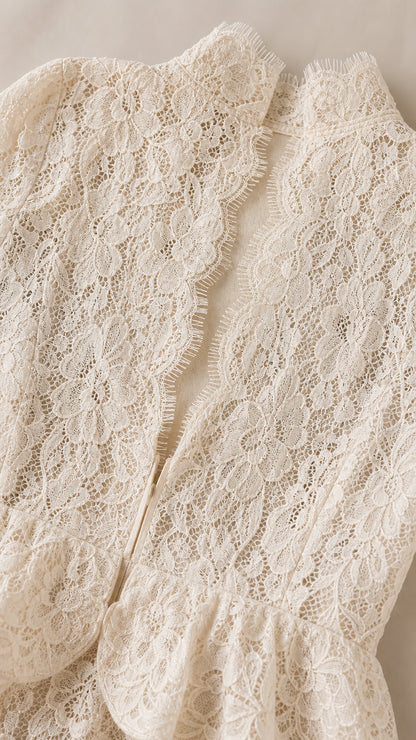 Close up texture of ivory floral lace fabric and scalloped eyelash edge