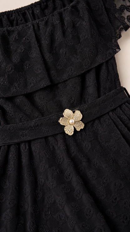 Close up of textured black Swiss dot fabric and floral waist belt