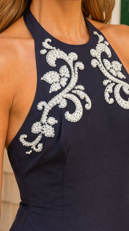 Close up detail of white beaded floral embroidery on halter neckline