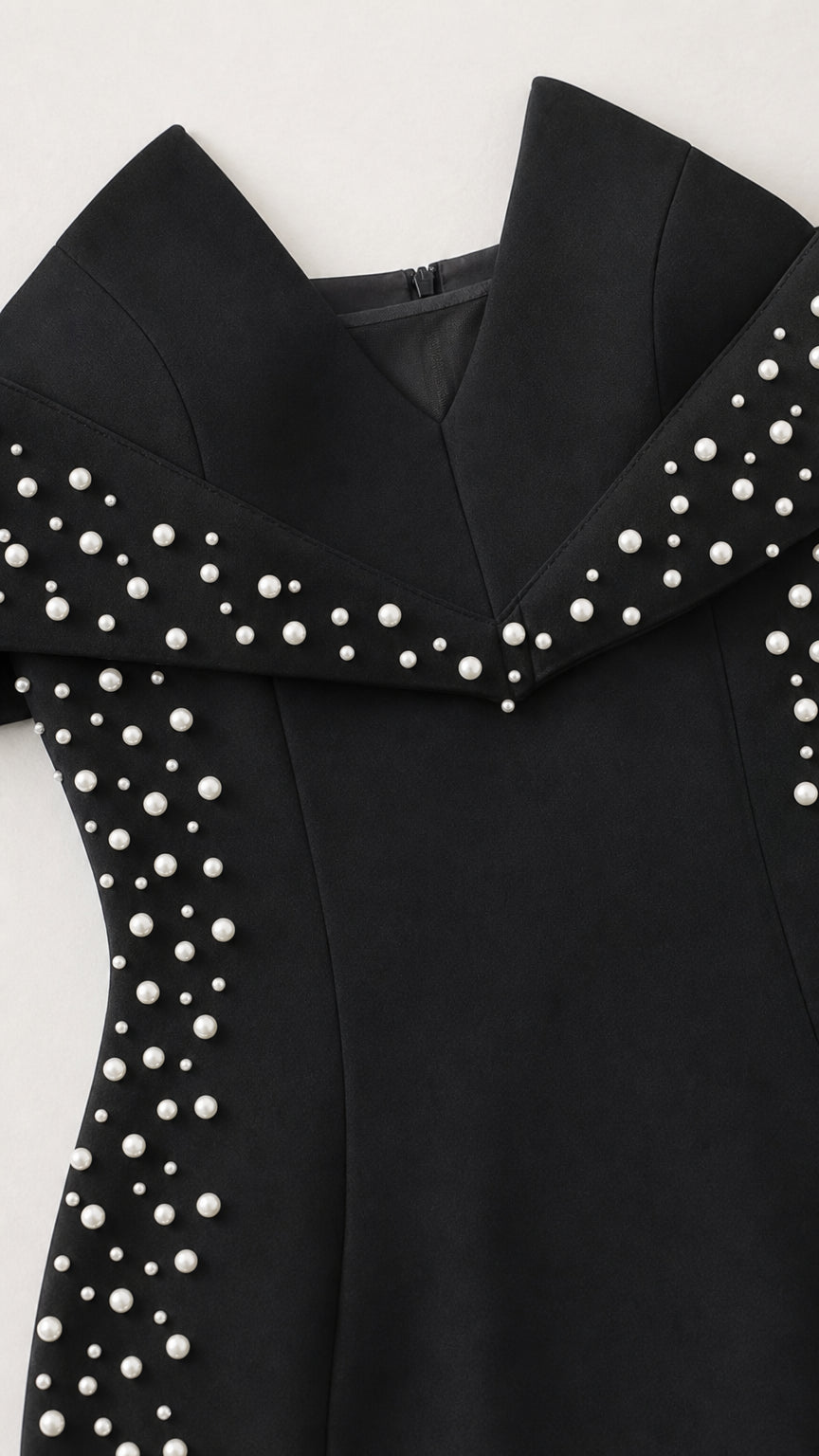 Close-up detail of off-the-shoulder collar with delicate pearl embellishments