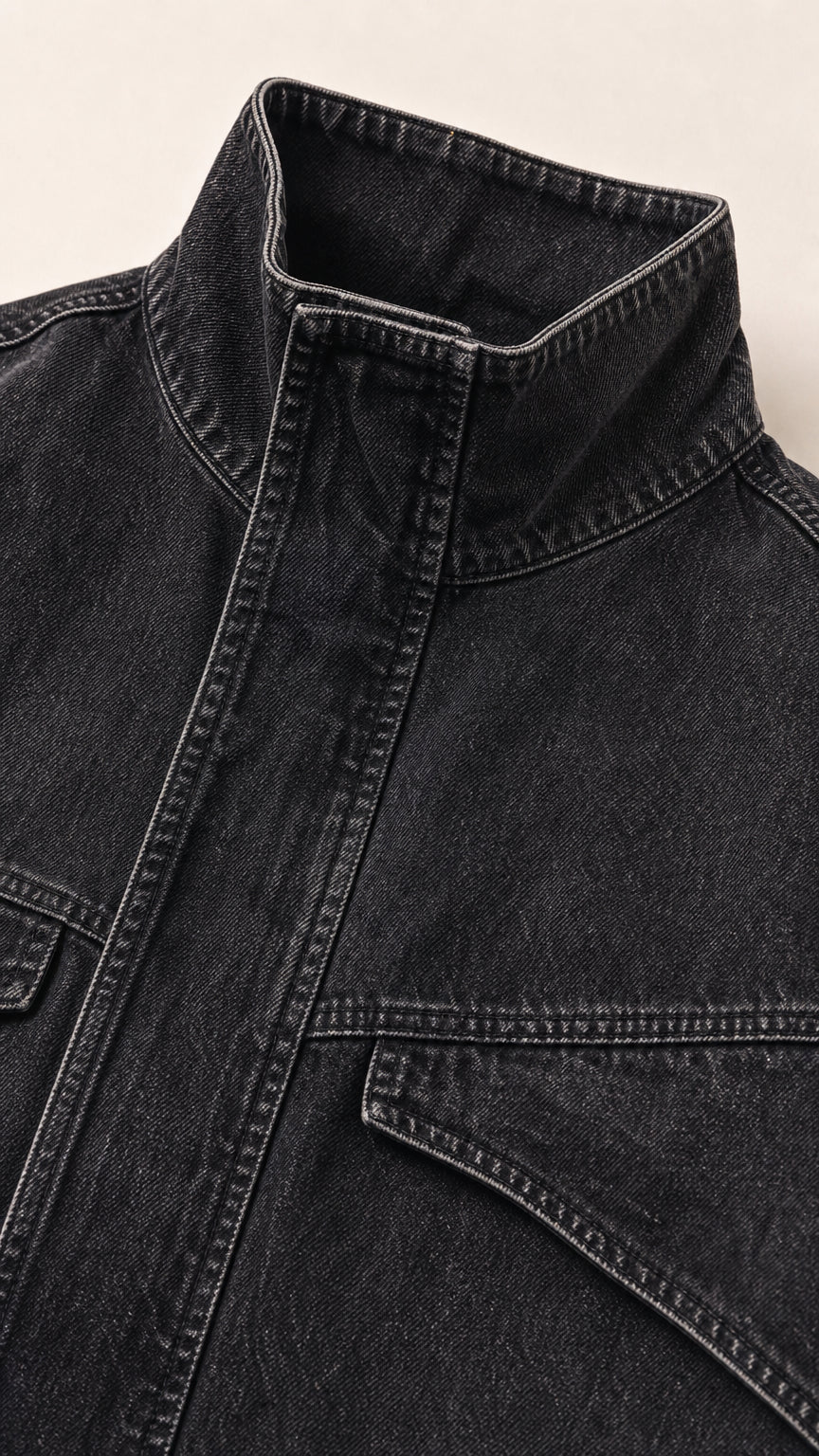 Close up detail of washed black high funnel collar and denim stitching