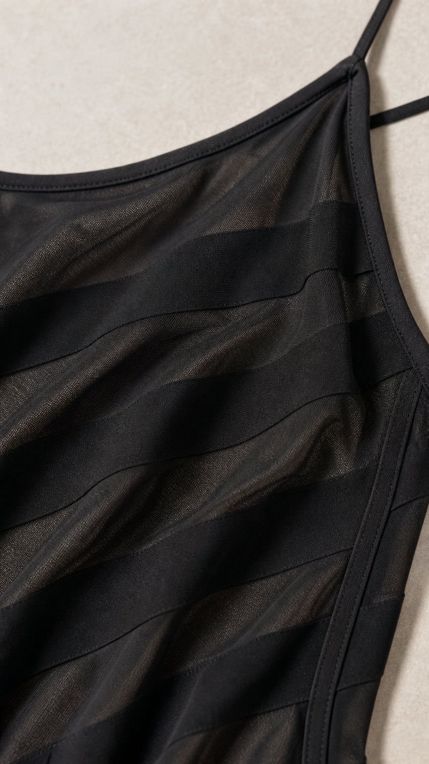 Close-up of the textured sheer striped black fabric and spaghetti straps