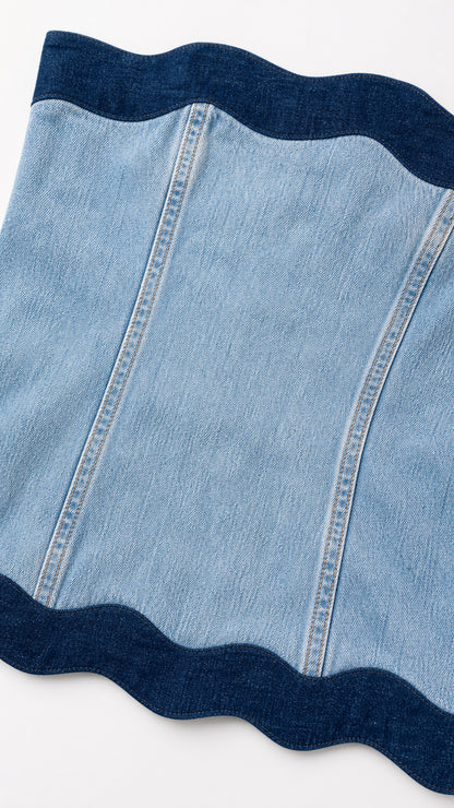 Close-up detail of contrast dark blue stitching and scalloped trim