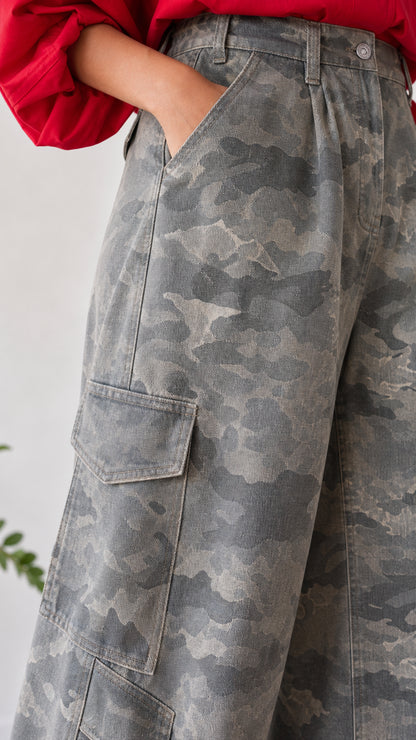 Close-up detail of pleated high waist and side cargo flap pocket on grey camo pants