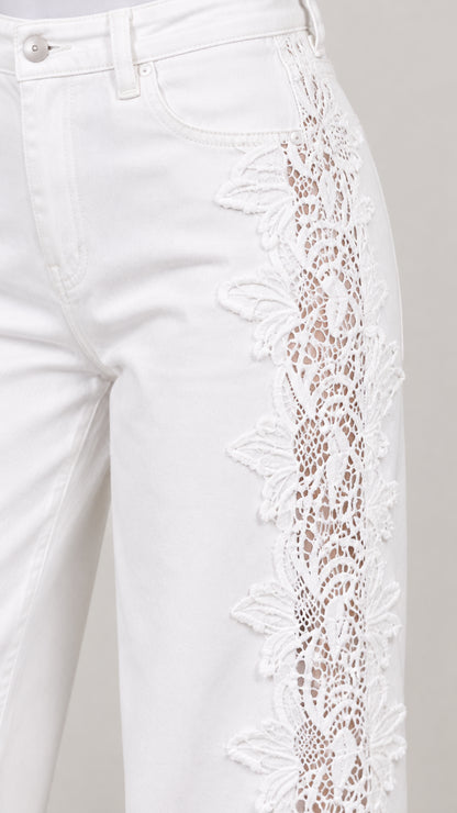 Close-up detail of white denim pocket and intricate floral lace side crochet insert