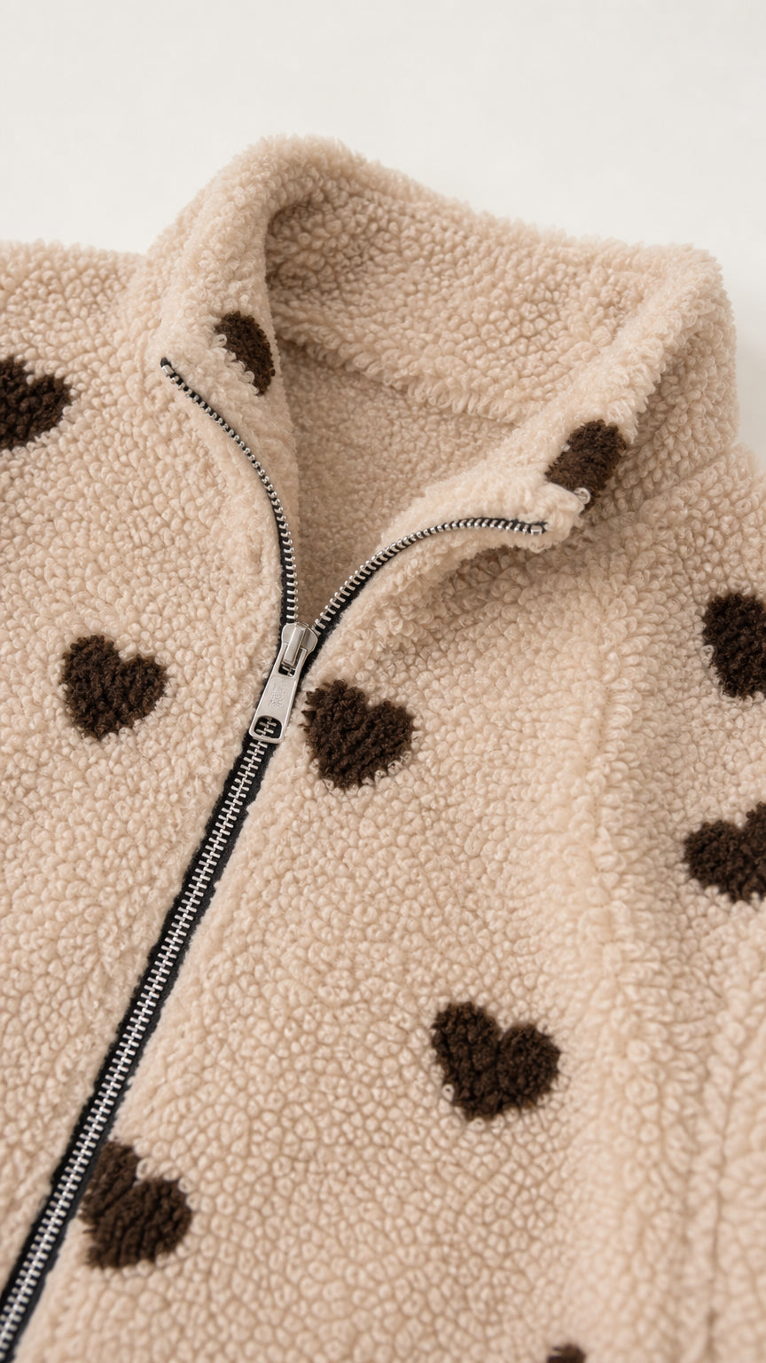 Close-up detail of zipper and collar on khaki sherpa jacket