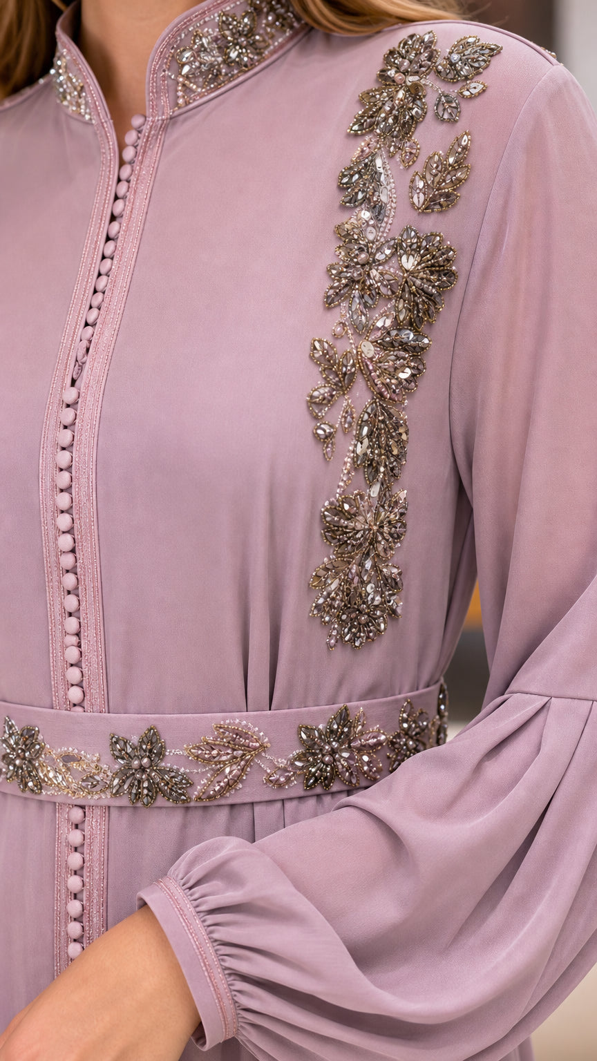 Close-up detail of intricate floral beadwork, rhinestone waistband, and button trim