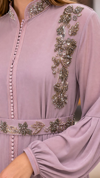 Close-up detail of intricate floral beadwork, rhinestone waistband, and button trim