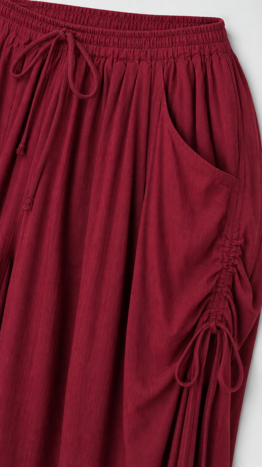 Close-up detail of side pocket and drawstring on burgundy pants