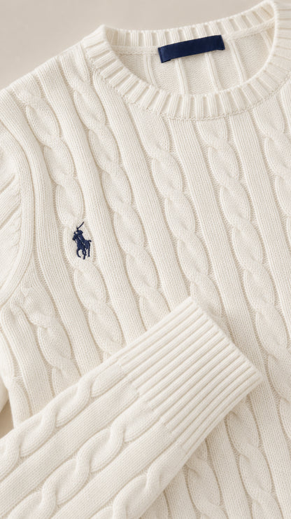 Close up of white cable-knit pattern fabric, crew neckline, and ribbed cuff detail