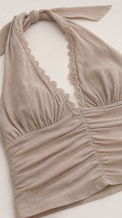 Close-up detail of beige halter top neckline with lace trim and ruching