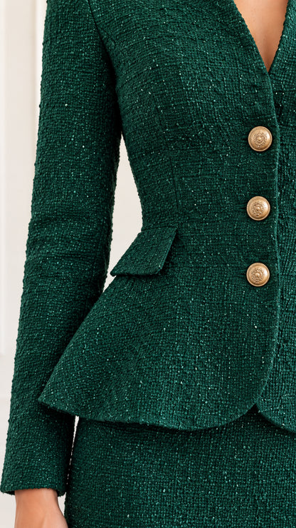 Close-up detail of emerald green textured tweed jacket with gold embossed buttons and flap pocket