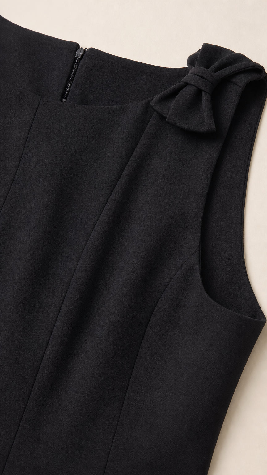 Close-up detail of neckline, fabric, back zipper, and shoulder bow accent