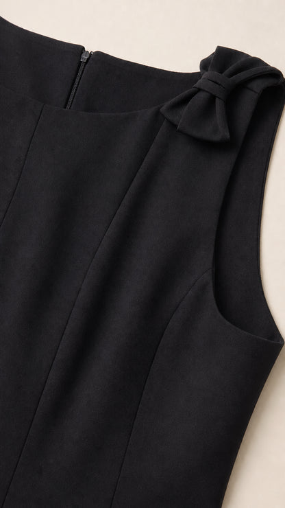 Close-up detail of neckline, fabric, back zipper, and shoulder bow accent