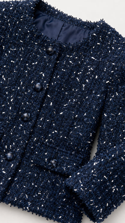 Close up of navy blue tweed jacket showing textured fabric, buttons, and neckline