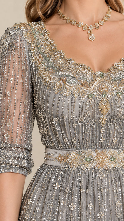Close-up detail of ornate crystal neckline and embellished waistband on silver gown