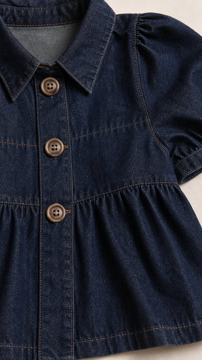 Close-up of dark denim top showing collar, buttons, and puff sleeve