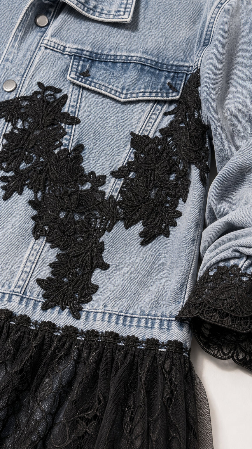 Close-up detail of chest and hem black lace appliques on blue denim jacket