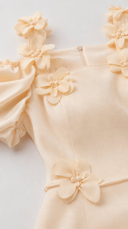 Close-up detail of 3D flowers and puff sleeves on cream dress