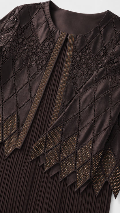 Close-up detail of embroidery and pleating on dark brown jacket