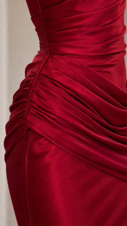 Close-up detail of side hip ruched gathering on ruby red satin fabric