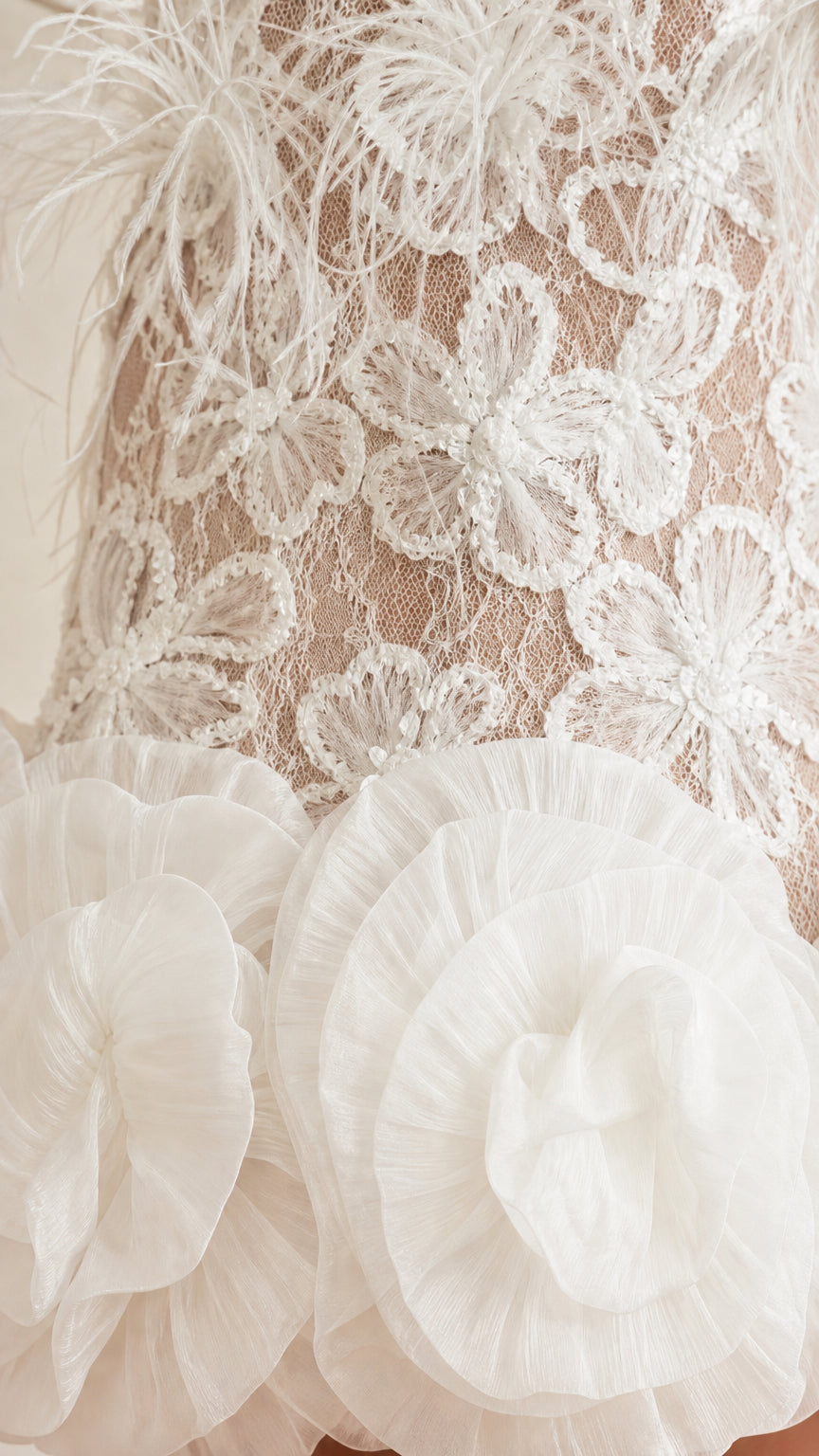 Close-up detail of white floral lace texture and organza ruffle hem