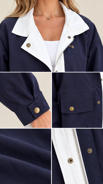 Close-up of the navy jacket's contrast collar, snap details, cuff, pocket, and smooth woven texture