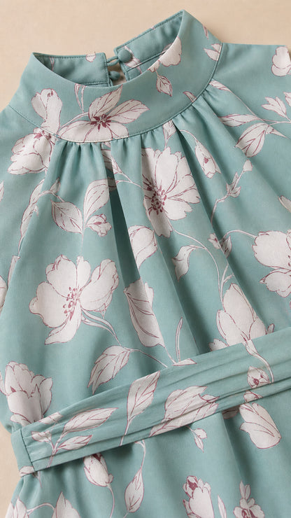 Close-up detail of gathered halter neck and pleated waistline on floral dress