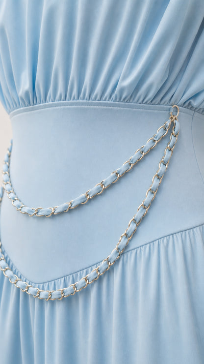 Close-up detail of draped bodice and metallic chain waist