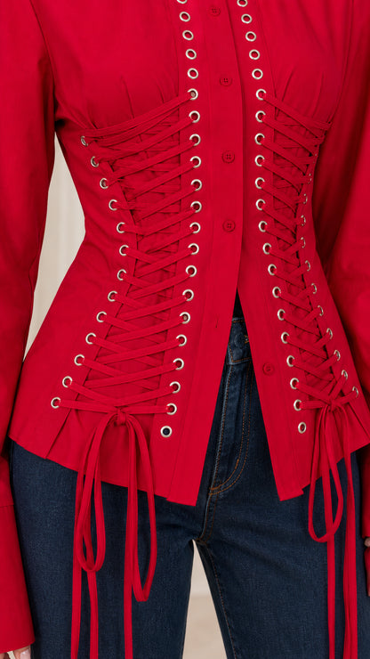 Close-up detail of front metal grommets and lace-up corset ties on red blouse