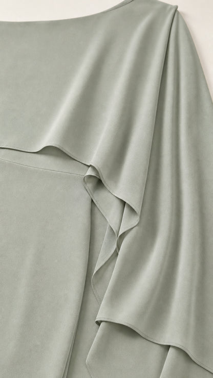 Close-up detail of smooth fabric and draped cape overlay