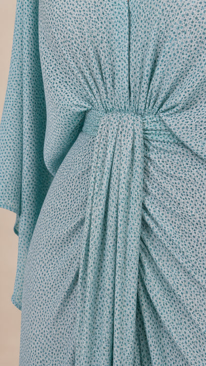 Close-up detail of front knot and gathered draping on light blue dress
