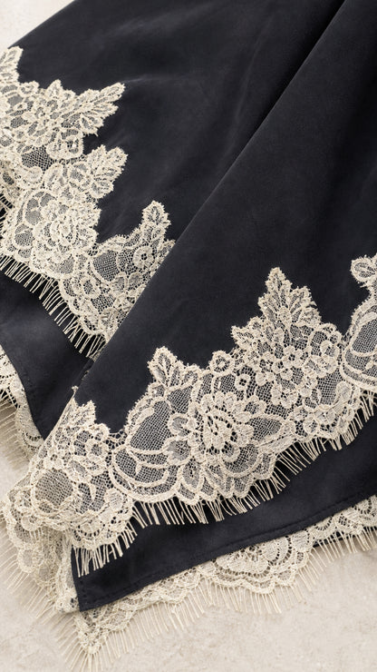 Close-up of black fabric and detailed lace hem