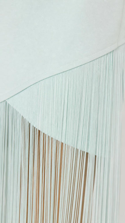 Close-up detail of mint asymmetric fringe hem