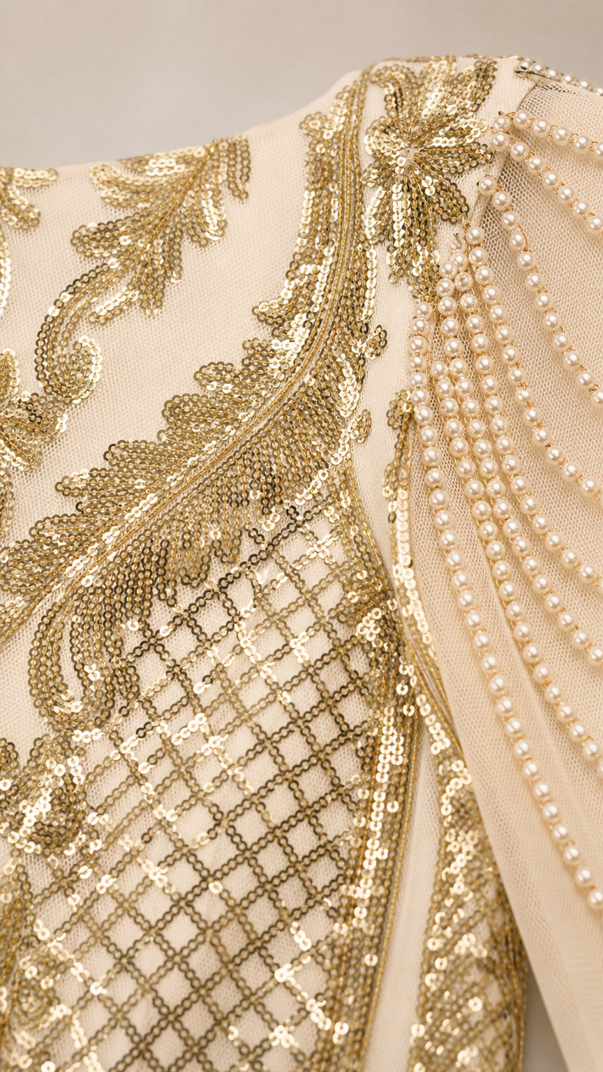 Close-up detail of champagne gold sequin embroidery and cascading beaded shoulder fringe