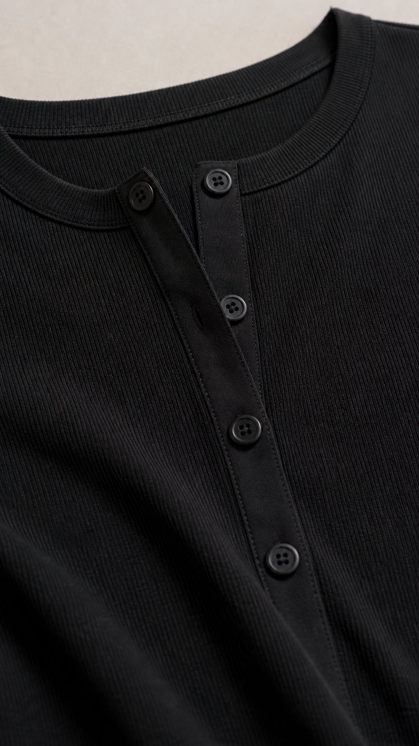 Close-up detail of black ribbed fabric and button placket