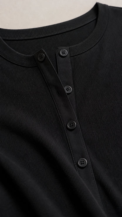 Close-up detail of black ribbed fabric and button placket