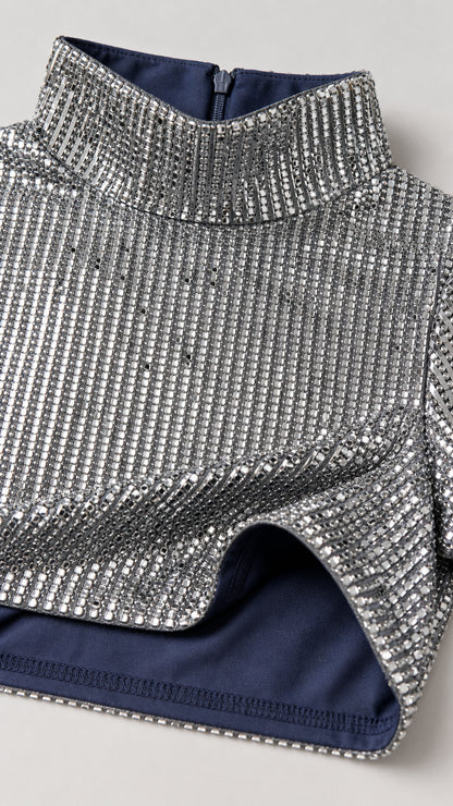 Close-up of silver sequin fabric and high neckline detail