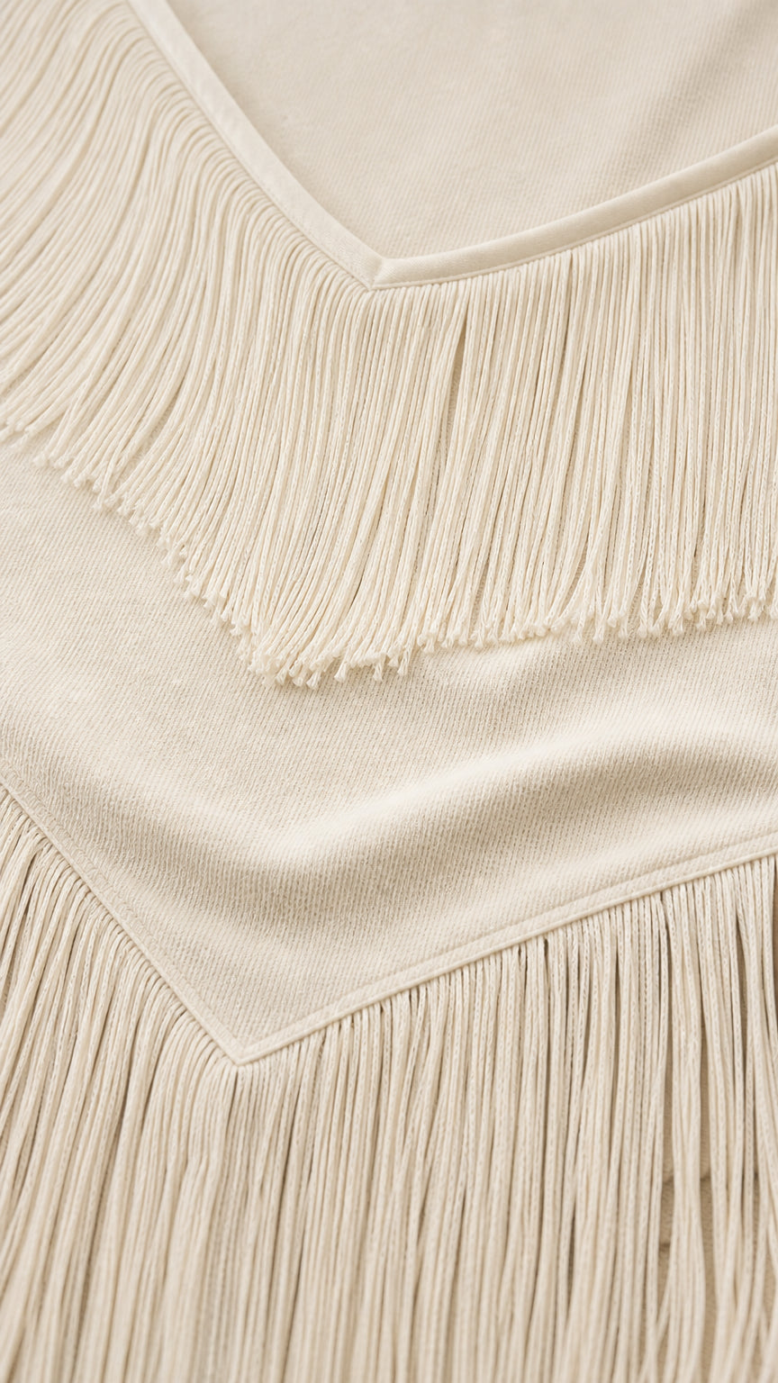 Close-up detail of knitted fabric and delicate fringe trim on bodice