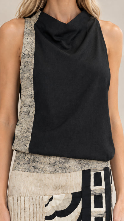 Close-up detail of cowl neckline and textured waist accent on black maxi dress
