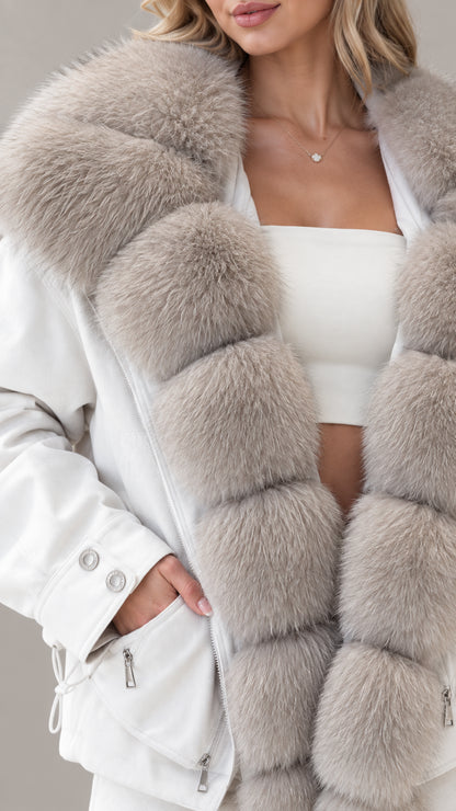 Close-up detail of white jacket showing zip pocket, cuff buttons, and thick plush faux fur trim