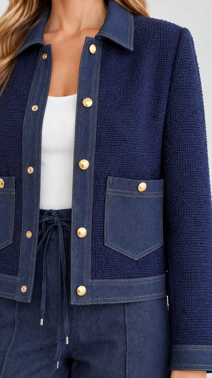 Close-up detail of textured fabric, gold buttons, and front pocket design in navy blue